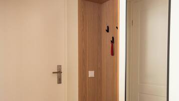Ein Flur mit einem Holzschrank, einer Tür mit Griff und einem gemusterten Boden.