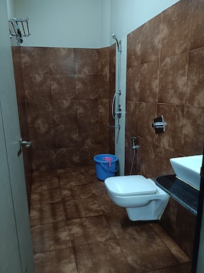 A small bathroom with a shower, toilet, and sink.