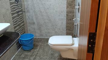 Et badeværelse med toilet, vask og bruser.