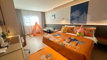 A hotel room with a bed, a desk, a chair, a small table, and a window with curtains.