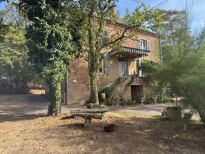 A rustic building with a stone facade, a wooden bench, and potted plants. - Kate's cozy home in Burgundy. (Bray)