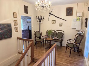 A dining area with a chandelier, wooden chairs, a table, and framed artwork on the walls. - Kate's cozy home in Burgundy. (Bray)