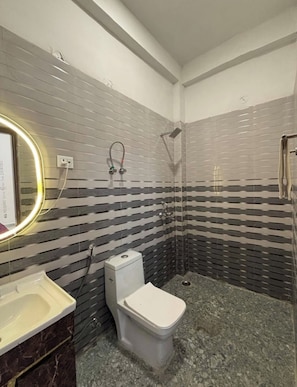 Un baño con inodoro, lavamanos y ducha.