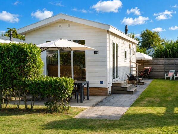 Een stacaravan met een terras, nummer 186, en een kleine tuin.