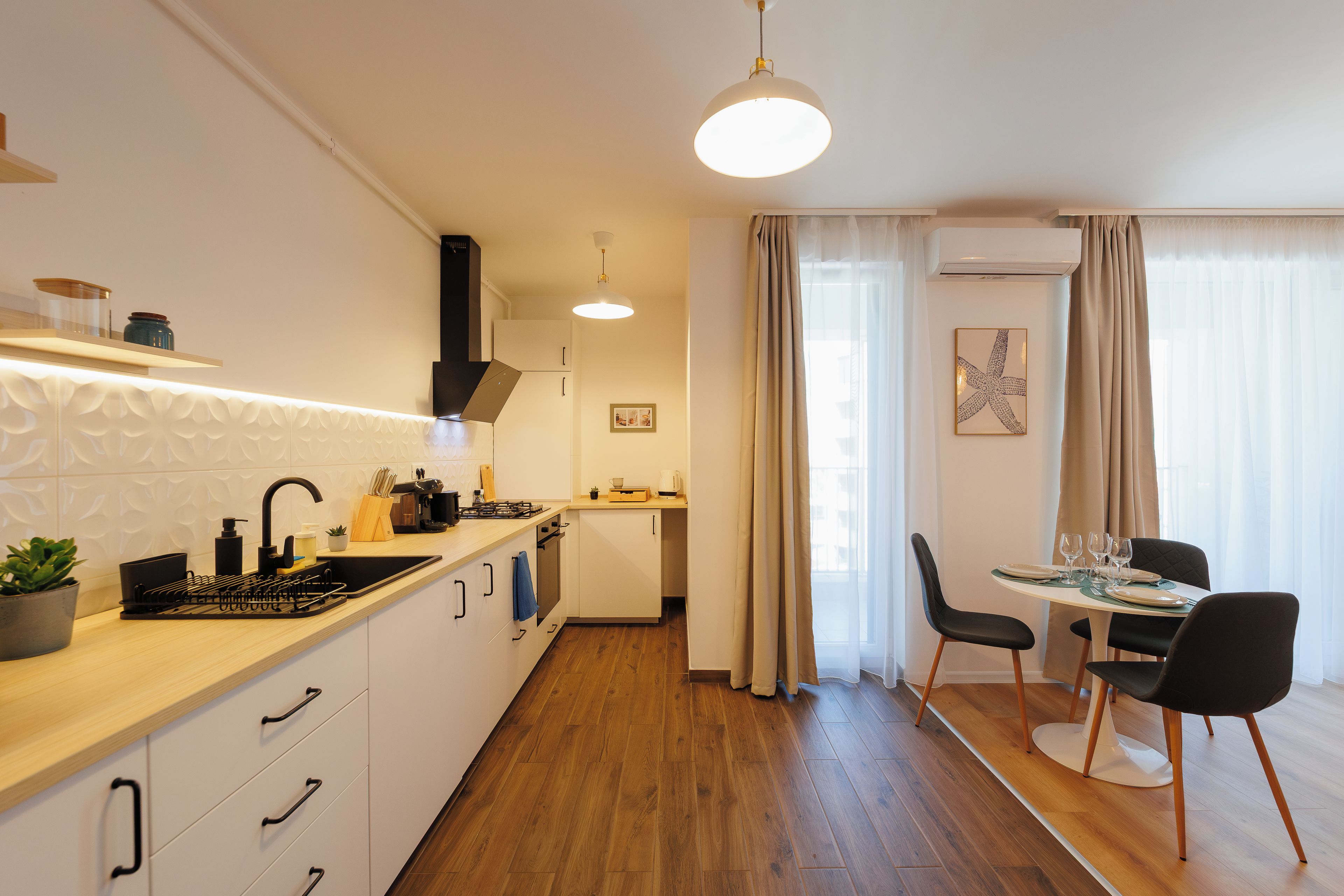 Une cuisine moderne avec un coin repas, un plancher en bois et une vue sur la ville.