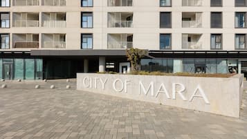 En byggnad med flera våningar, balkonger, en skylt med texten ”CITY OF MARA” och ett belagt entréområde.