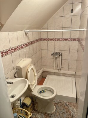 Une petite salle de bain avec des toilettes, un lavabo et une baignoire.