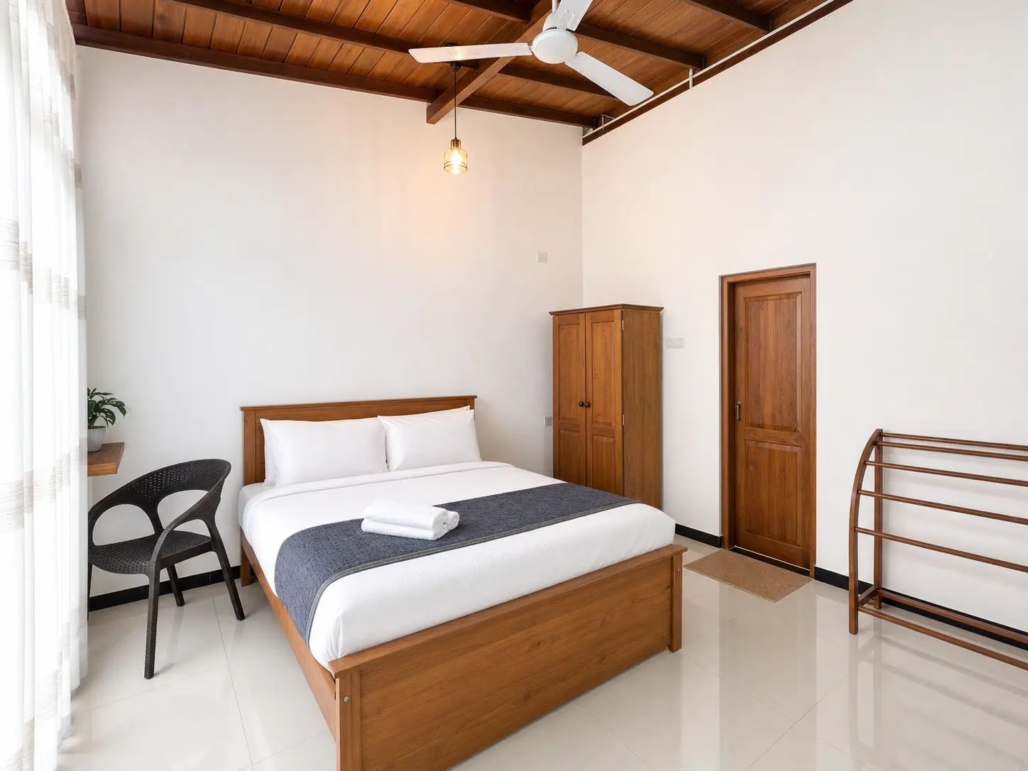 Un dormitorio con una cama de madera, un armario, una silla y un ventilador de techo.