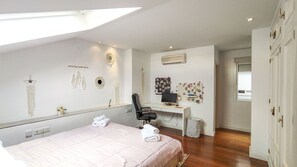 Une chambre à coucher avec un lit, un bureau et un ordinateur.