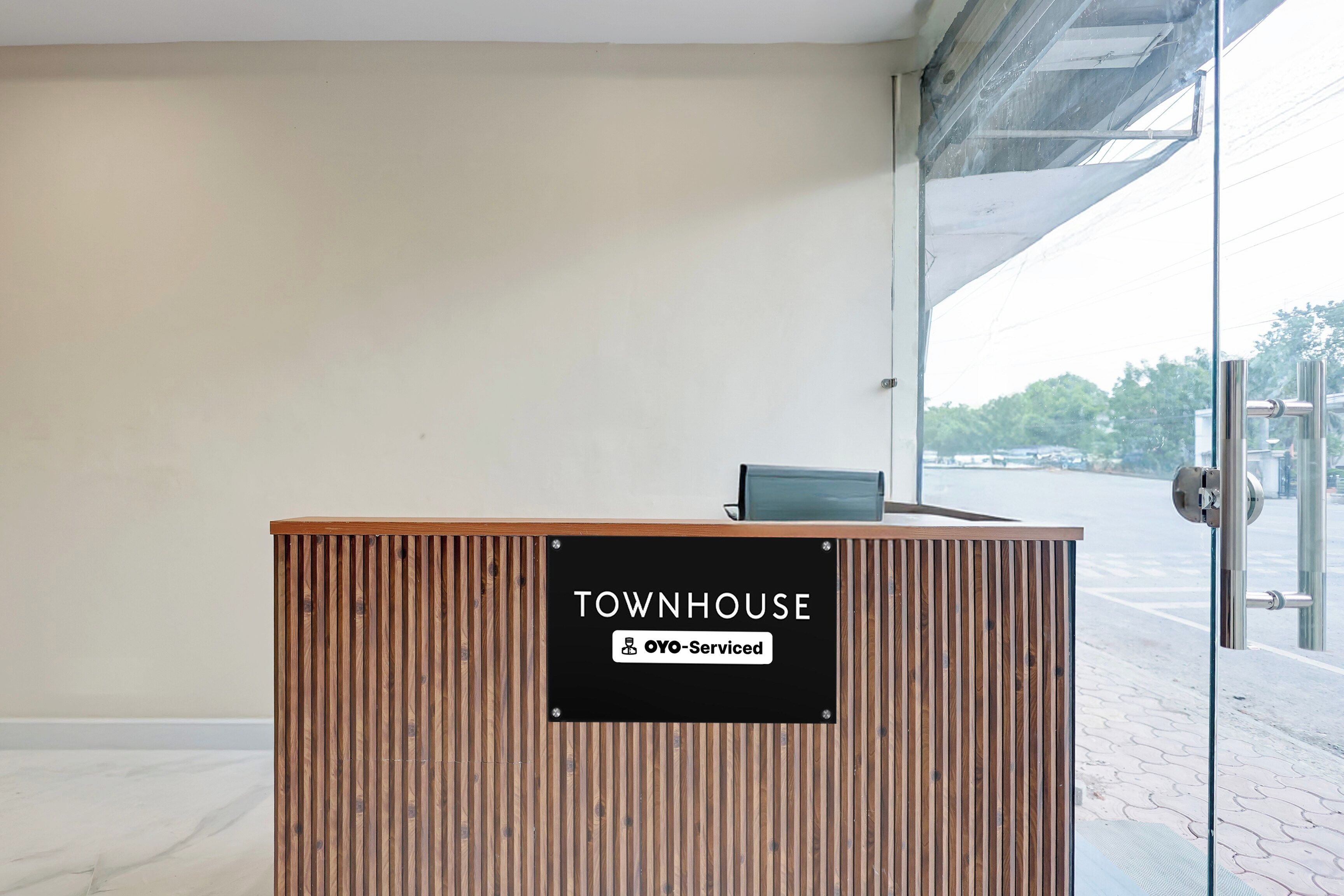 Un mostrador de recepción con un cartel que indica 'TOWNHOUSE' y servicios 'YO-Serviced'.