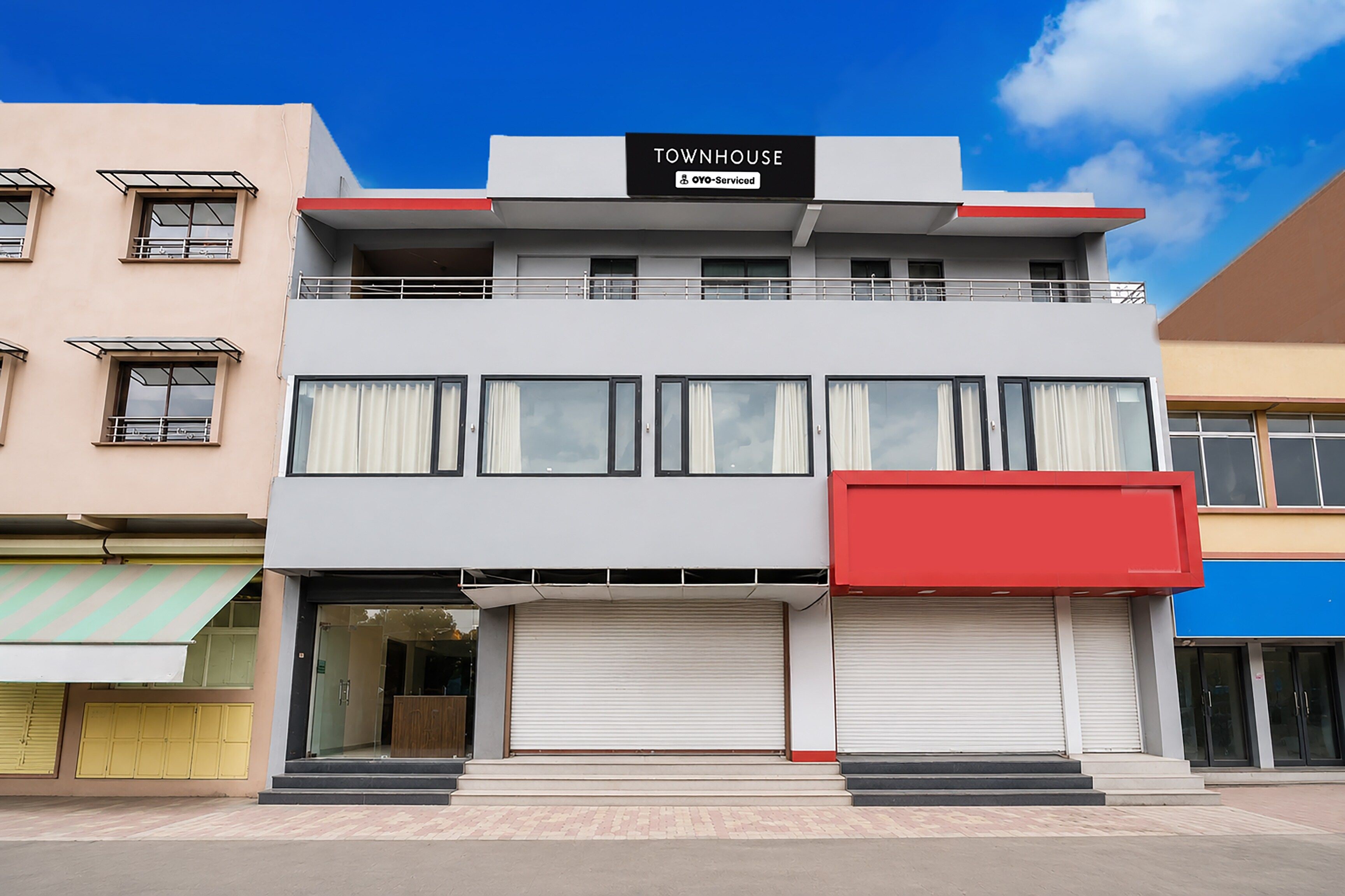 A two-story building with a sign reading 'TOWNHOUSE' and 'YOY-Serviced'.