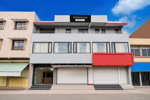 A two-story building with a sign reading 'TOWNHOUSE' and 'YOY-Serviced'. - Super Townhouse Dewas Bus Terminal (Ujjain)