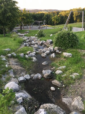 A natural outdoor setting with a stream, rocks, and greenery. - "Kräuterwiese" House, 535 square meters (Frasdorf)