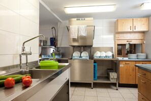 A modern kitchen with stainless steel appliances, a built-in dishwasher, and wooden cabinets. - "Kräuterwiese" House, 535 square meters (Frasdorf)