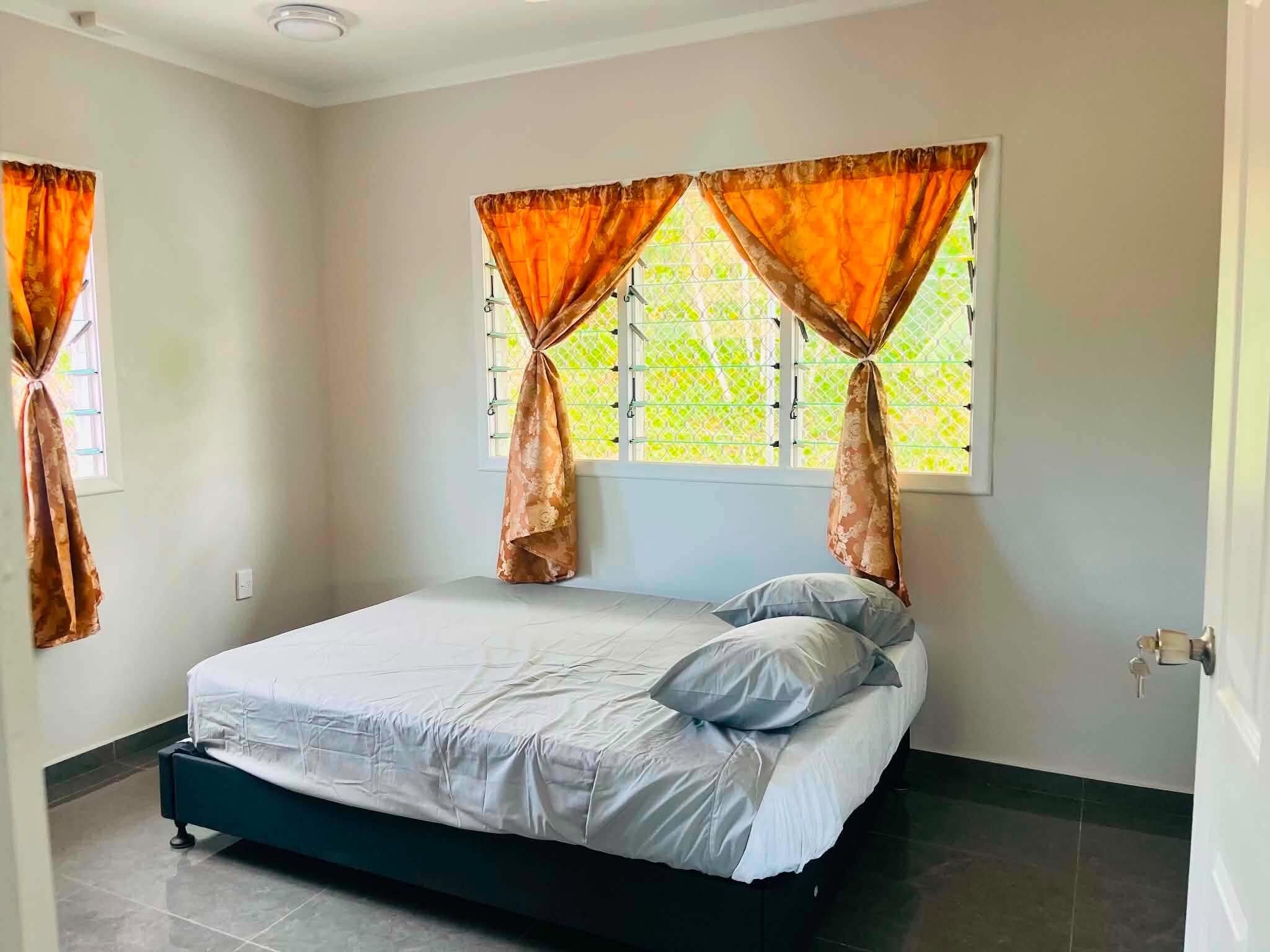 Un dormitorio con cama, cortinas y ventana.