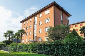 A multi-story building with a flat roof and rectangular windows. - 2BR with Balcony and Mountain Views near Lugano (Magliaso)