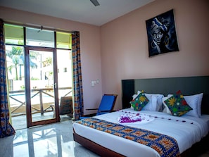 A hotel room with a bed, a painting, and a view of a pool area. - Double A Nungwi Seaview Hotel (Nungwi)
