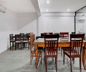Ein Konferenzraum mit einem langen Tisch und mehreren Stühlen, weißen Wänden und Deckenleuchten.