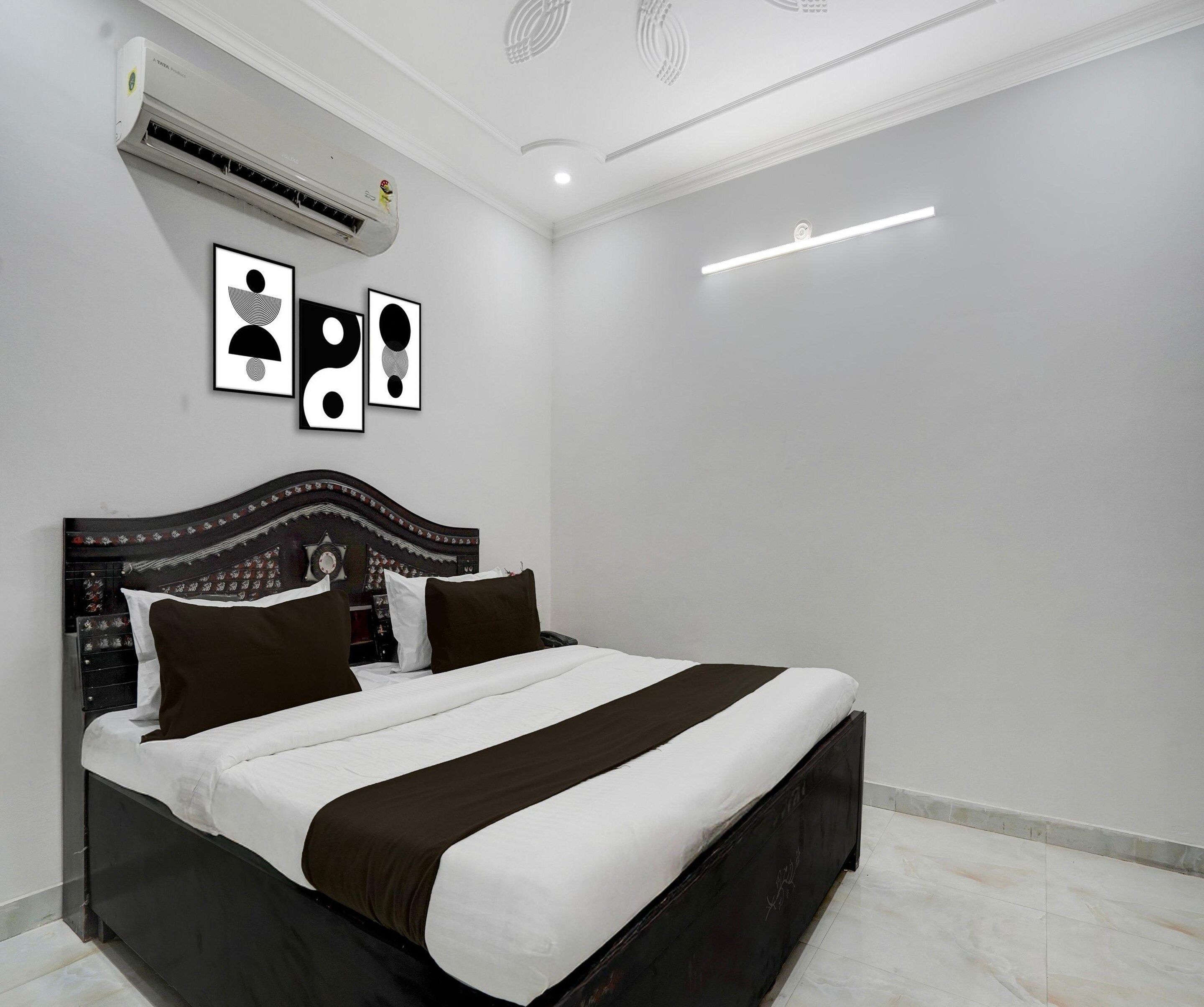 A modern bedroom with a large bed, a decorative headboard, and an air conditioning unit mounted on the wall.