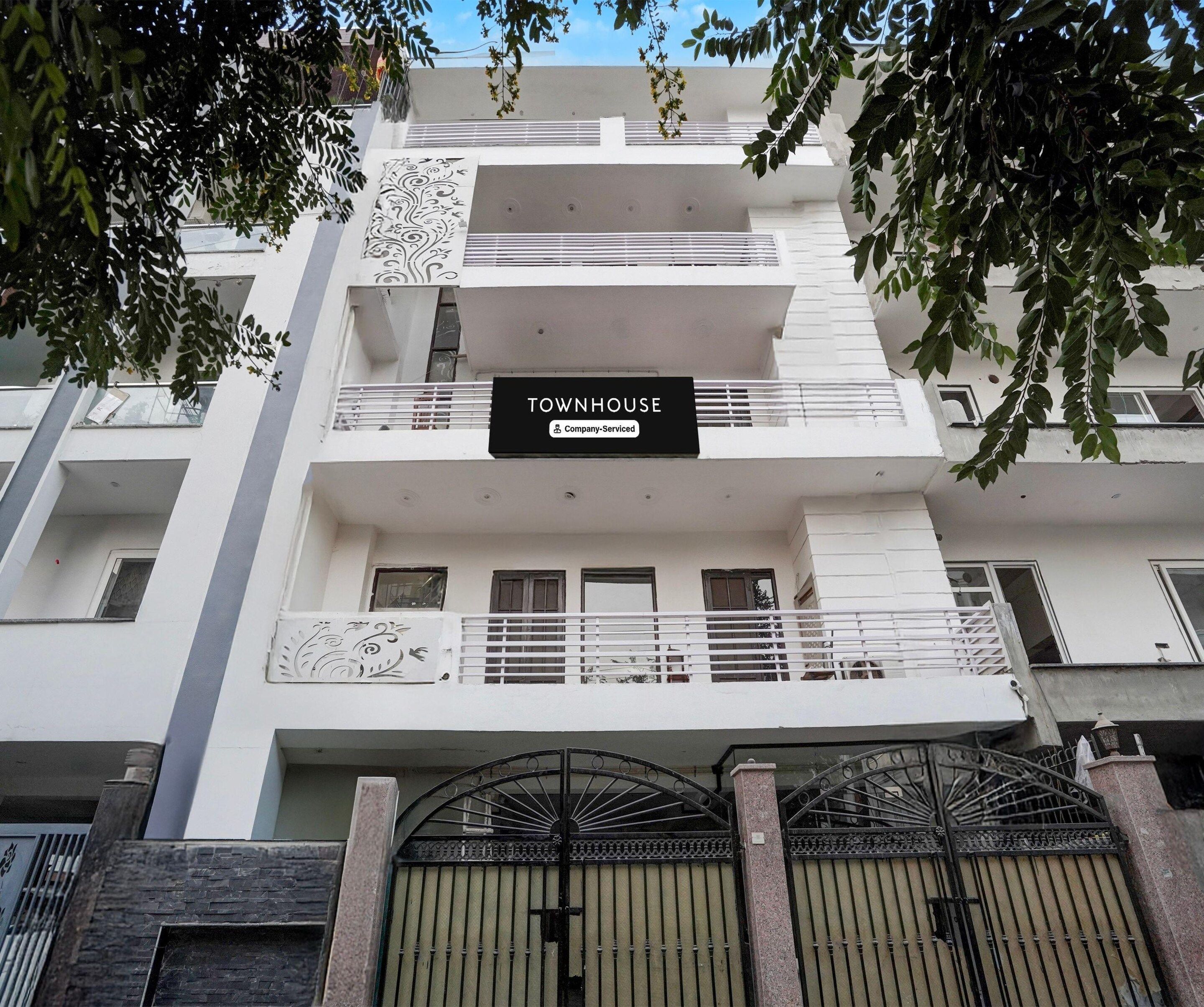 Un immeuble à plusieurs étages sur lequel on peut lire l'inscription : « TOWNHOUSE, entreprise offrant des services ».