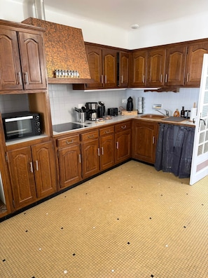 A kitchen with wooden cabinets, a microwave, a coffee maker, and a dishwasher.