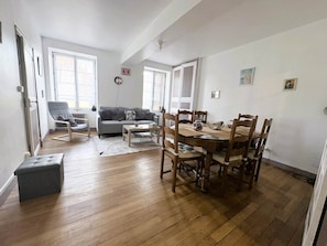 A compact living space with a dining area, a sofa, and a chair.