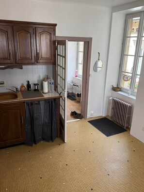 A kitchen with wooden cabinets, a sink, and a window.