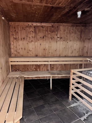 A sauna room with wooden benches and a tiled floor. - Mountain View Studio "Hana" - Adler Resort (Kaprun)
