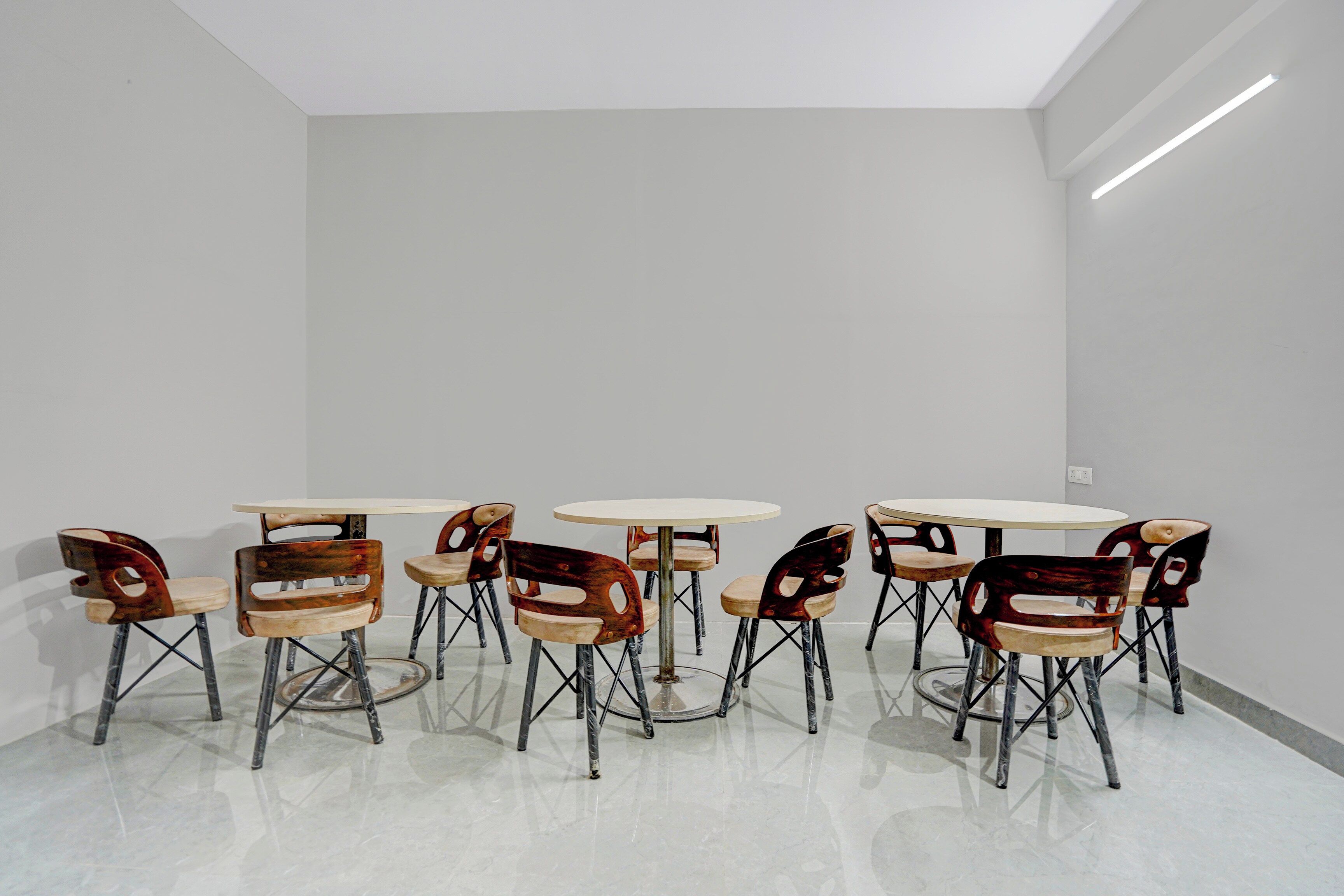 Una habitación con un diseño moderno y minimalista, que presenta una serie de mesas y sillas redondas de diseño escultórico y singular.