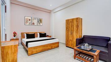 A hotel room with a wooden bed, a sofa, a wooden cabinet, and a coffee table.