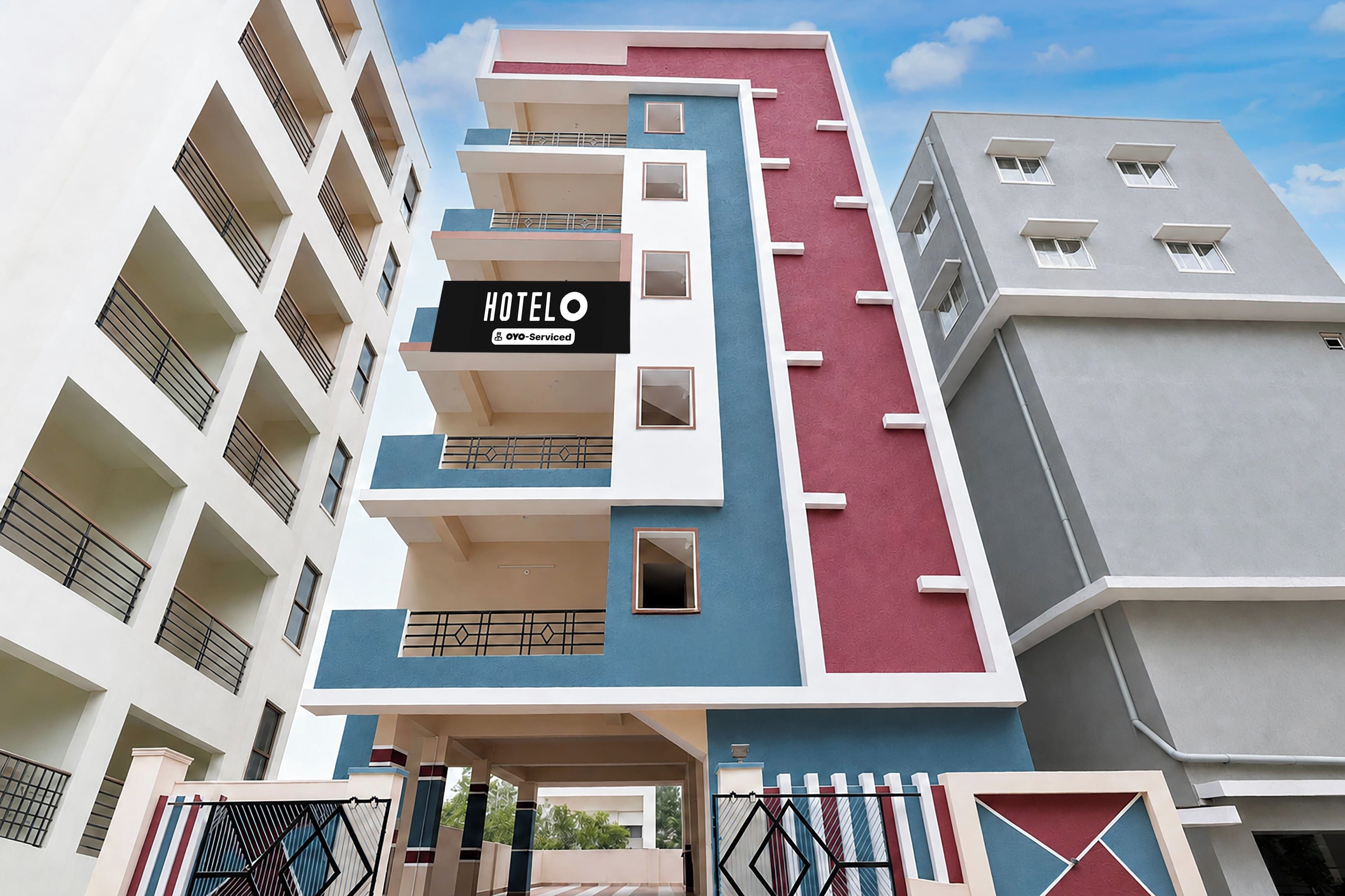 A multi-story hotel building with a sign indicating it is serviced by OYO.