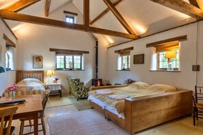 Ein gemütliches Schlafzimmer mit einem hölzernen Bett, einem Schreibtisch, einem Stuhl und einem Kamin.