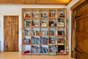 Una habitación con una amplia estantería de madera llena de libros y revistas.