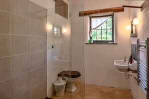 Ein Badezimmer mit Toilette, Waschbecken und Duschbereich.