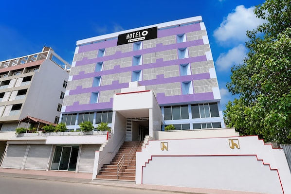 Un edificio moderno de hotel con un cartel que indica que cuenta con servicios de Oyo.