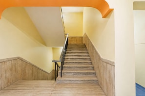 A staircase with a wooden handrail and marble steps. - Super Hotel O Durg Bus Stand (Ujjain)