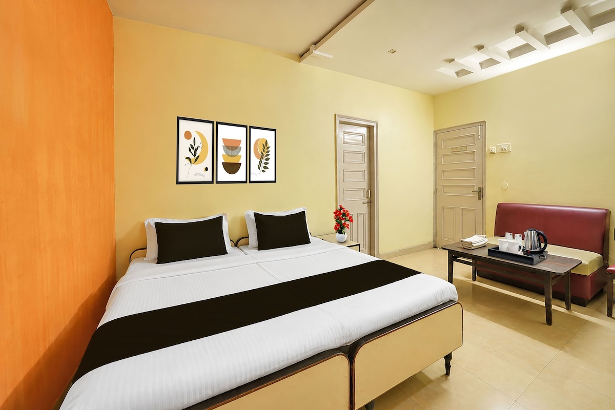 Una habitación de hotel con una cama, un escritorio, una silla y una puerta.