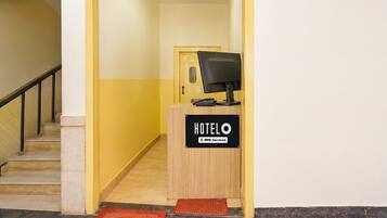 Un comptoir d’accueil d’hôtel avec une pancarte indiquant que l’établissement est géré par OYO.