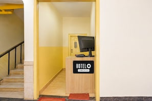 A hotel reception desk with a sign indicating it is serviced by OYO. - Super Hotel O Durg Bus Stand (Ujjain)