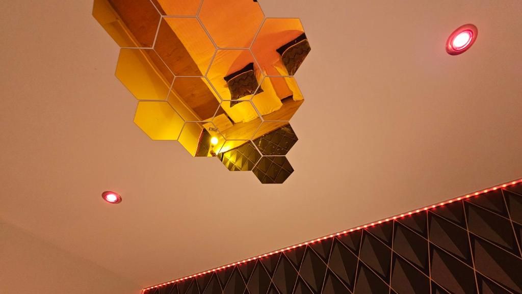 A geometric ceiling design with hexagonal patterns and recessed lighting.