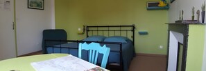 A room with a bed, a table, and a shelf with decorative items. - Bed and Breakfast 'Chambre Anis' with Shared Garden and Wi-Fi (Cheillé)
