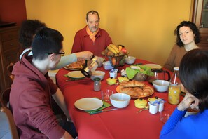 A dining table with food, drinks, and utensils.