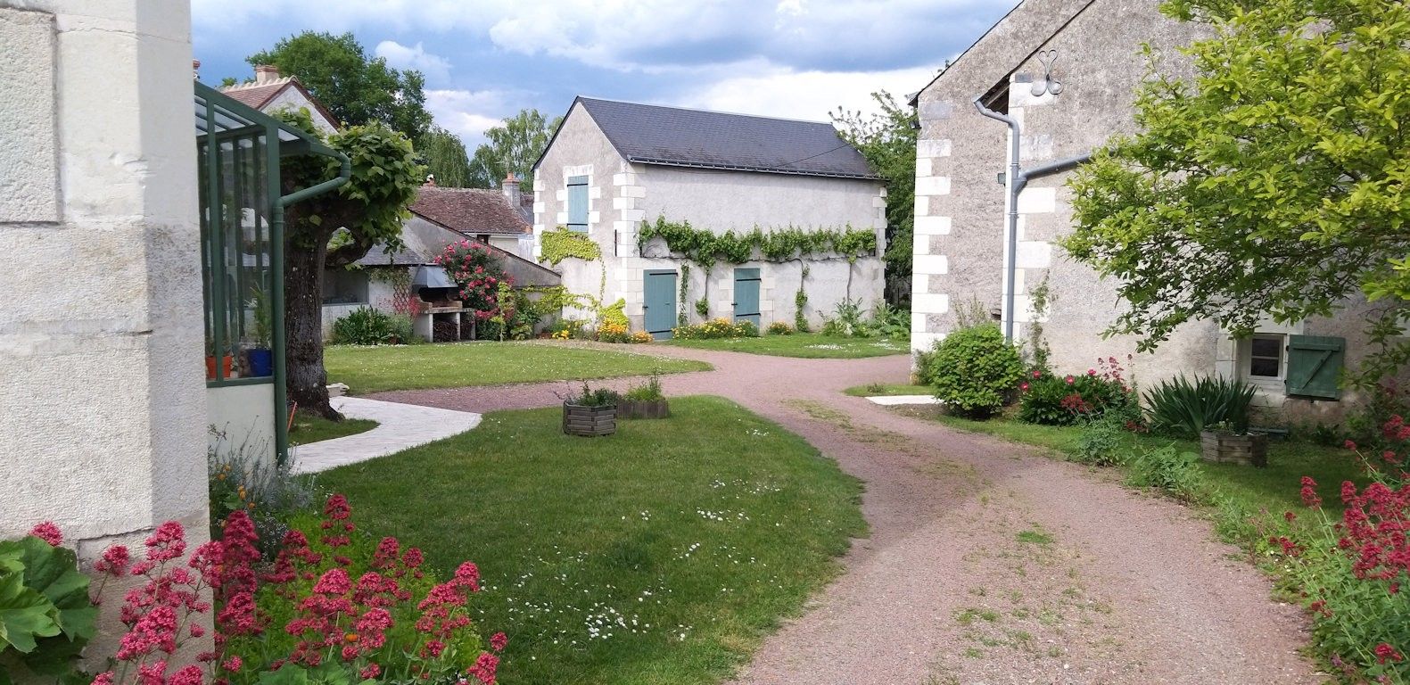 Een woonwijk met een verharde oprit naar een huis met een grijs dak en witte muren.