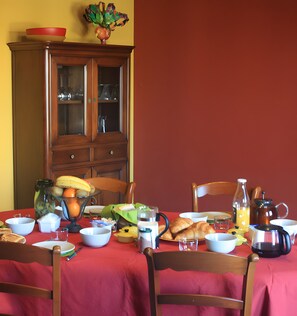 A dining table set with various dishes, glasses, and a coffee pot. - Bed and Breakfast 'Chambre Anis' with Shared Garden and Wi-Fi (Cheillé)