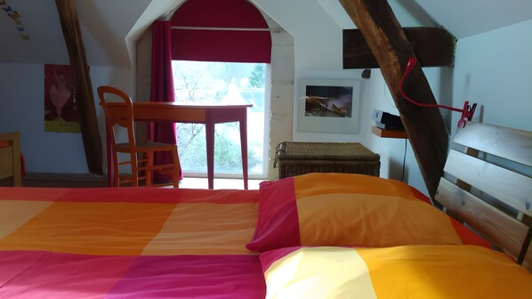 A bedroom with a bed, a desk, and a chair.