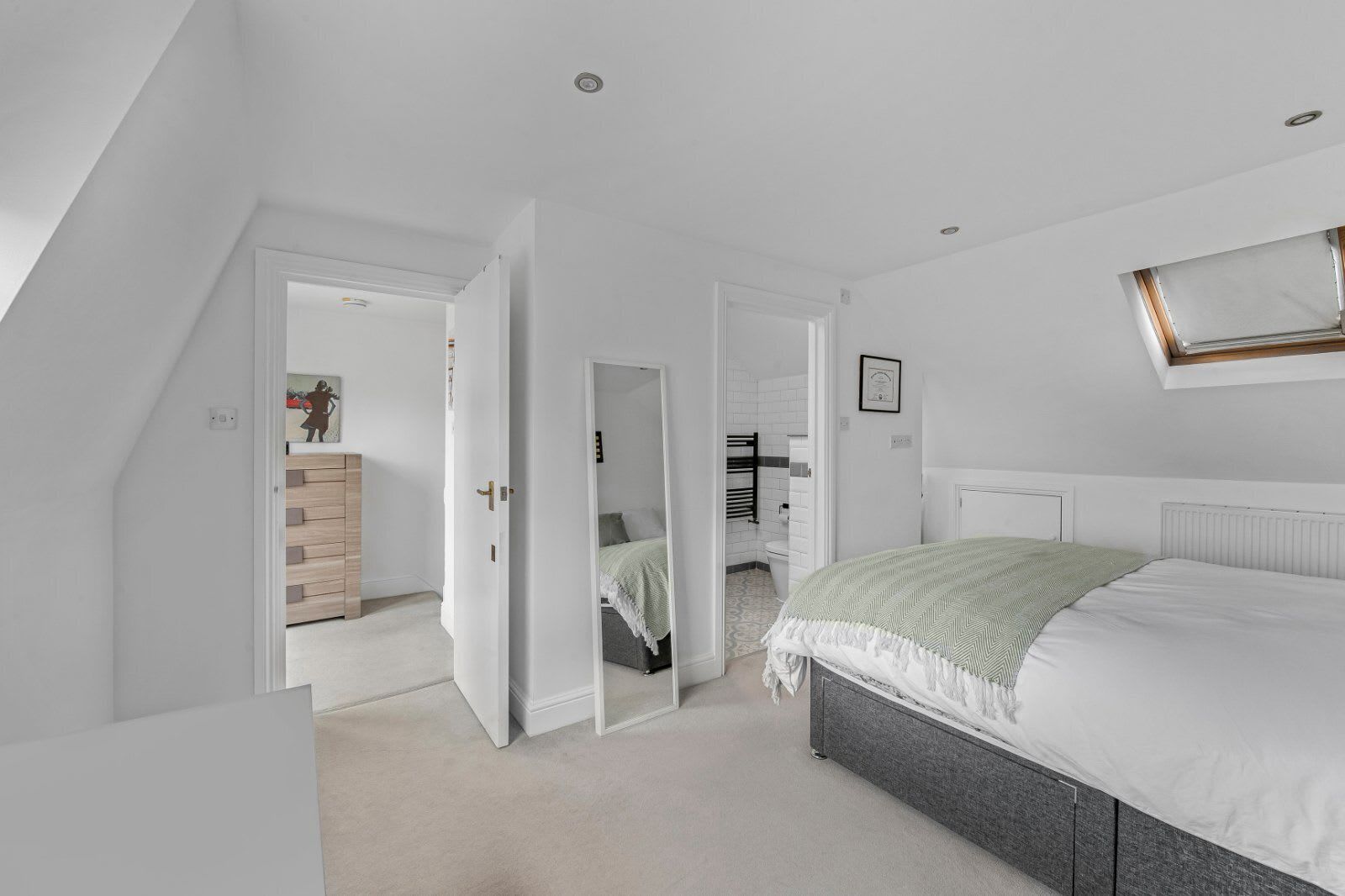 A bedroom with a bed, a radiator, and a window.