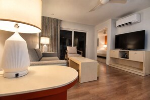 A modern hotel room with a flat-screen TV, a sofa, a coffee table, and a lamp. - 3x2BR ¼ mi to Kam 1 Beach, Pool, Hot Tub, Gym, BBQ (Kihei)