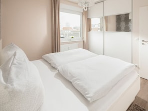 Ein Hotelzimmer mit einem Bett, einem Kleiderschrank und einem Fenster mit Vorhängen.