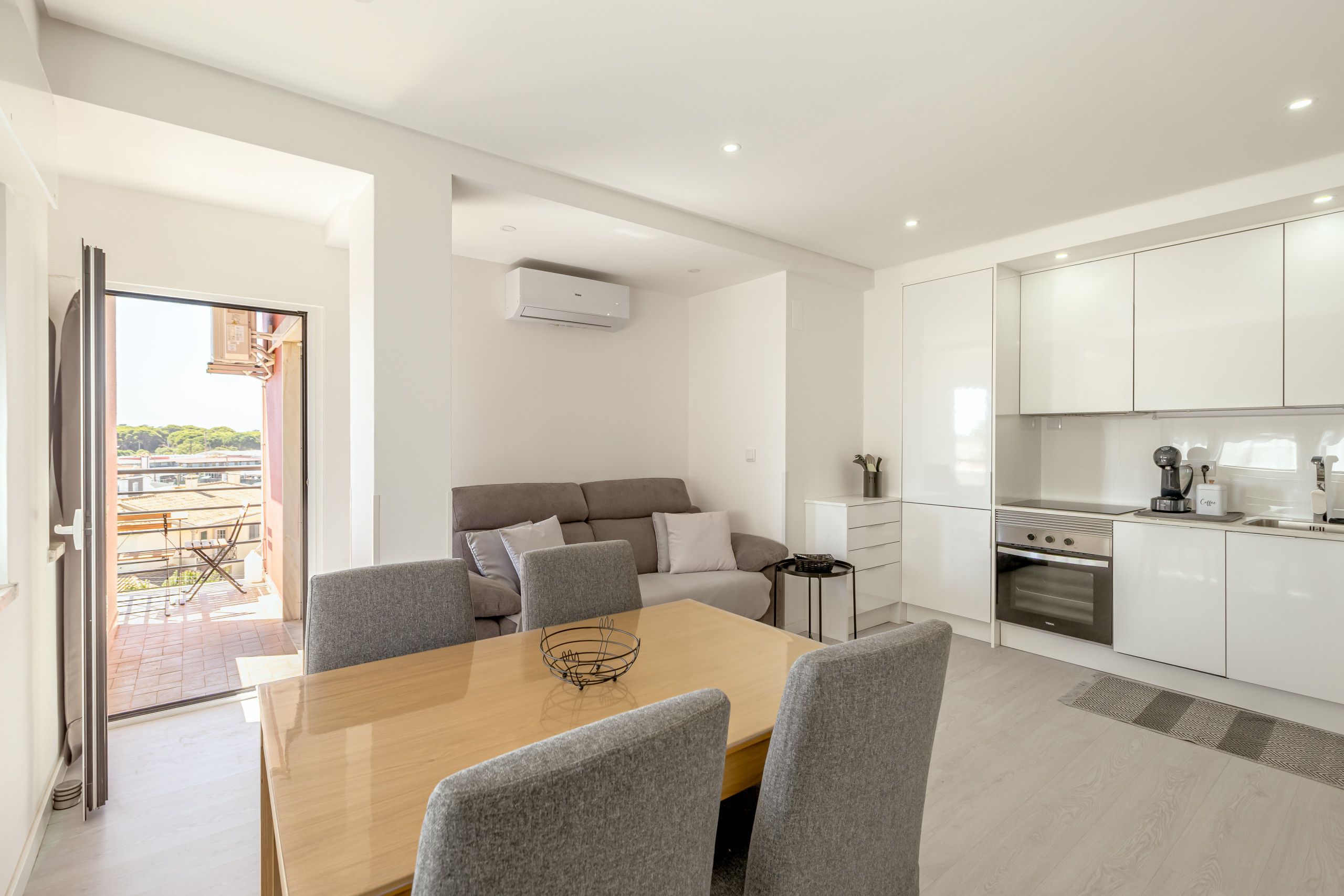 Un apartamento moderno con comedor, sofá, cocina y vistas al exterior.