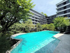 Ein modernes Gebäude mit einem Pool, umgeben von Bäumen.